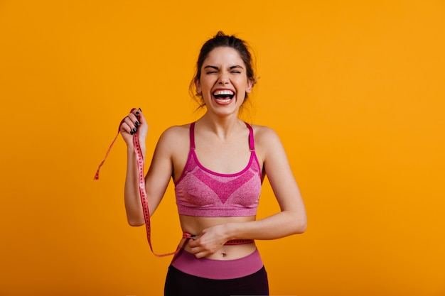 Mulher sorrindo com fita métrica